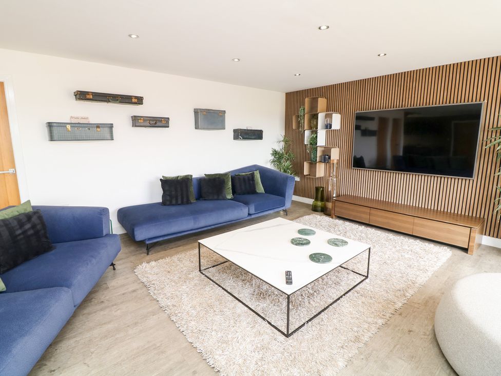 A living room with a coffee table and television at Hideaway in Scampton