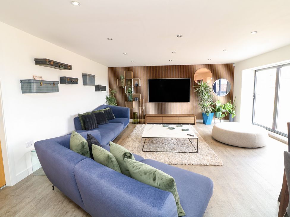 A living room with a sofa and TV at Hideaway in Scampton