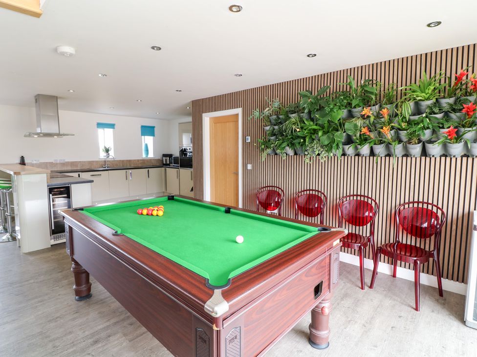 A snug with a pool table and red chairs at Hideaway in Scampton