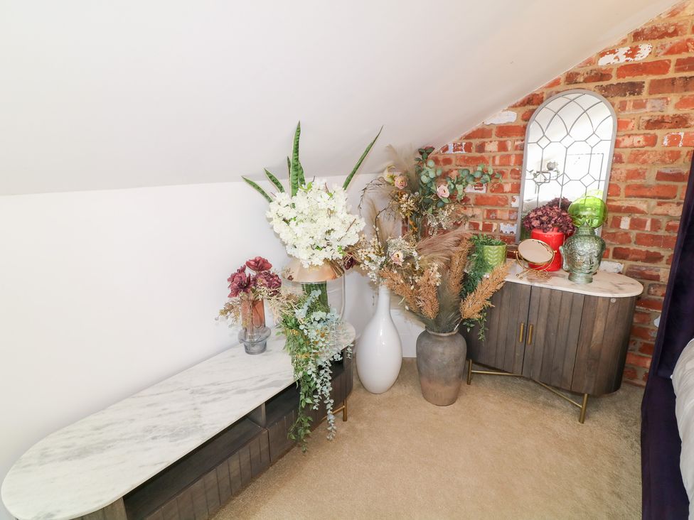 A bedroom with a table and flowers at Hideaway in Scampton