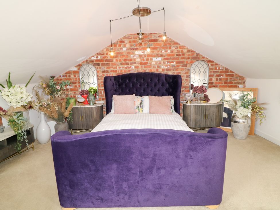 A bedroom with a purple bed and nightstands at Hideaway in Scampton