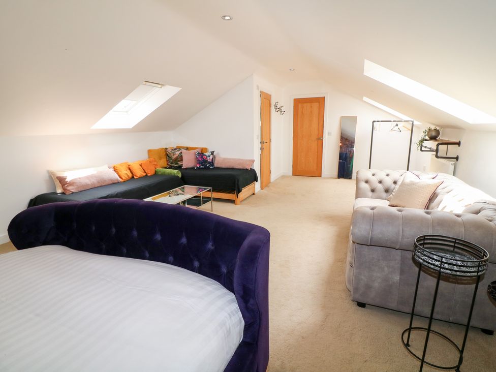 A bedroom with a bed and sofas at Hideaway in Scampton