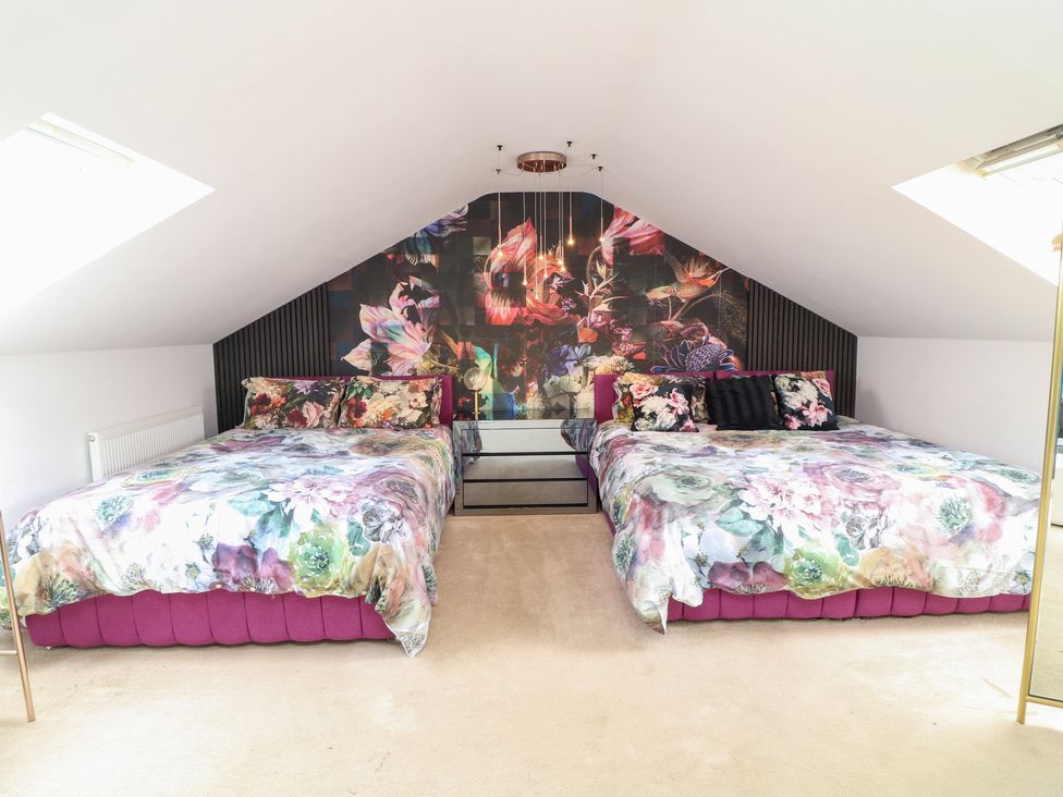 A bedroom with two beds and a wall mural at Hideaway in Scampton