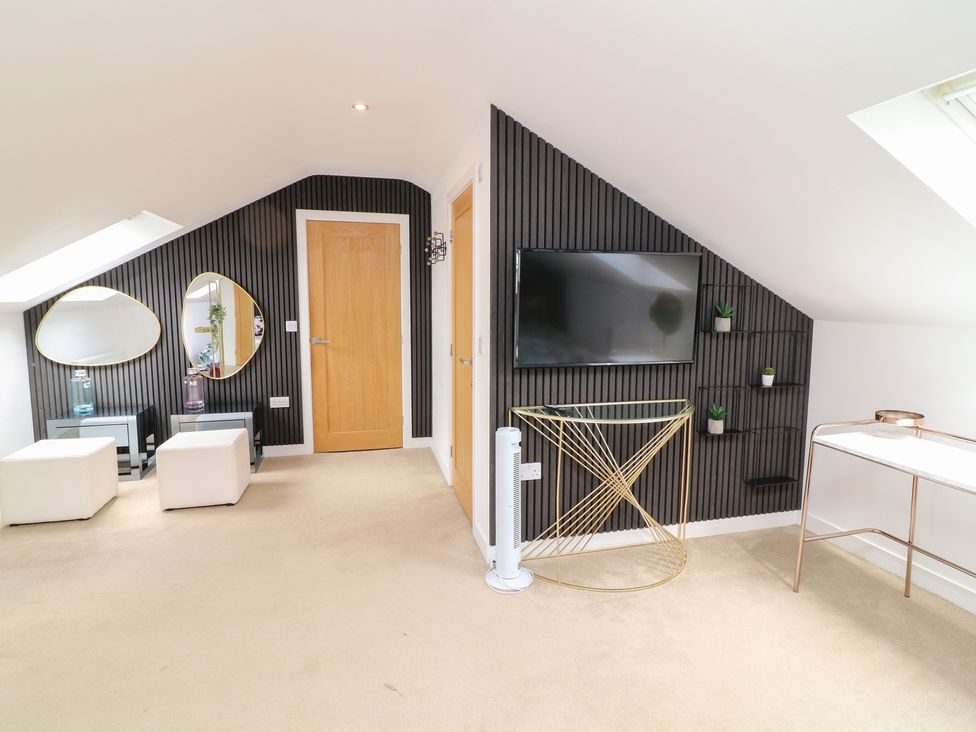 A living room with furniture and a television at Hideaway in Scampton