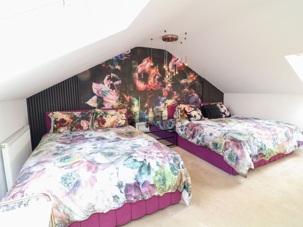 A bedroom with two beds and floral decorations at Hideaway in Scampton