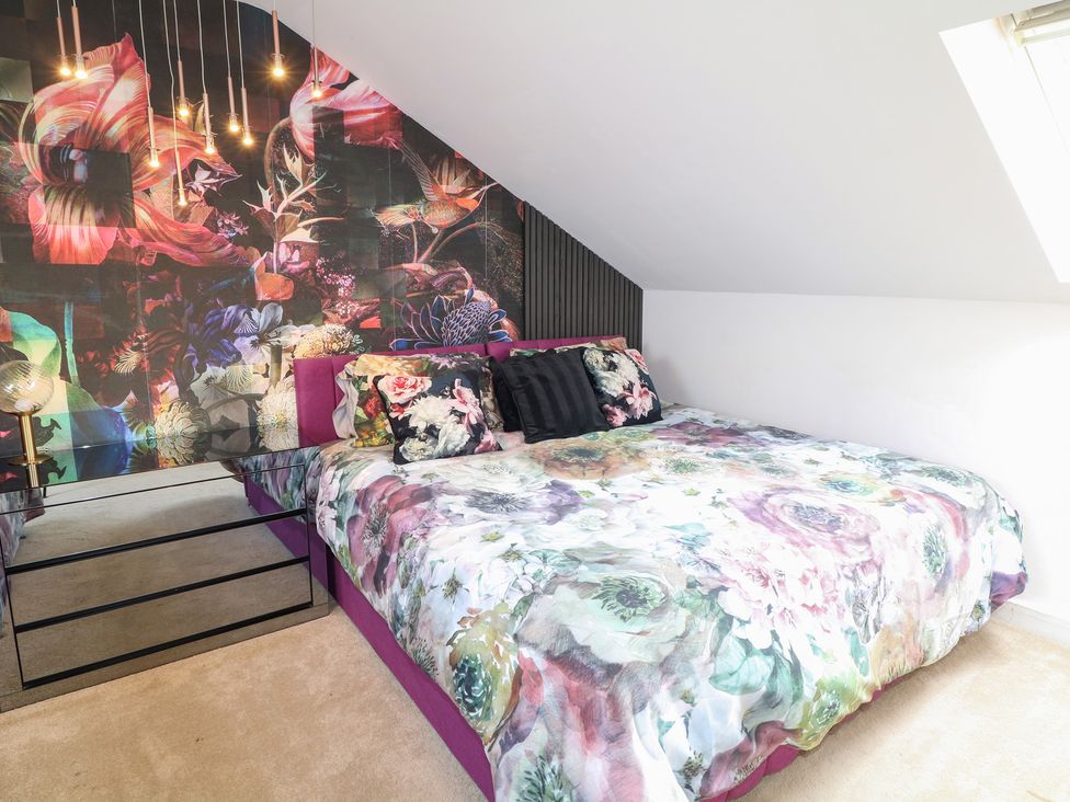 A bedroom with a bed and wall art at Hideaway in Scampton