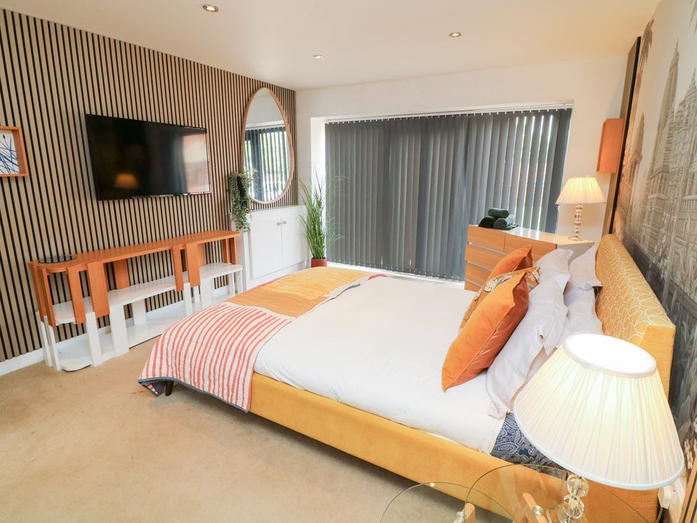 A bedroom with a bed and television at Hideaway in Scampton