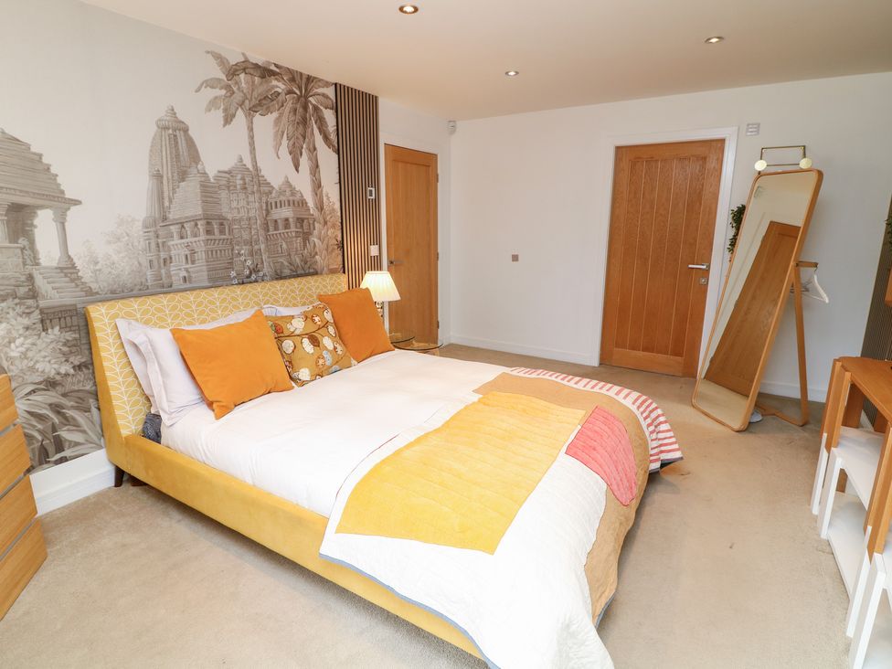 A bedroom with a bed and mirror at Hideaway in Scampton
