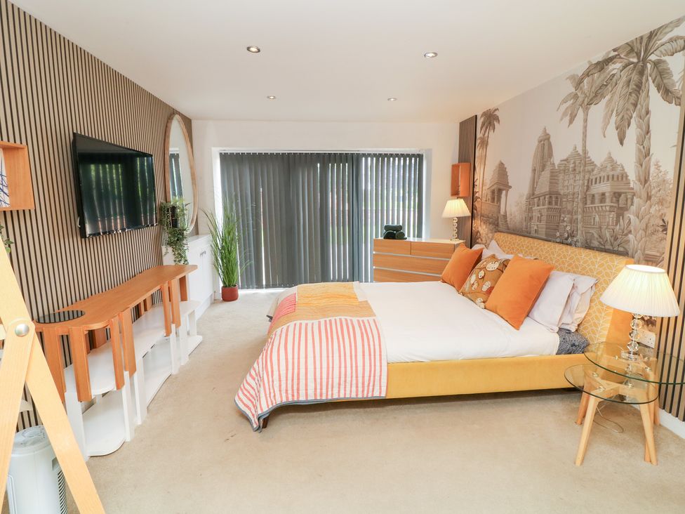 A bedroom with a bed and television at Hideaway in Scampton