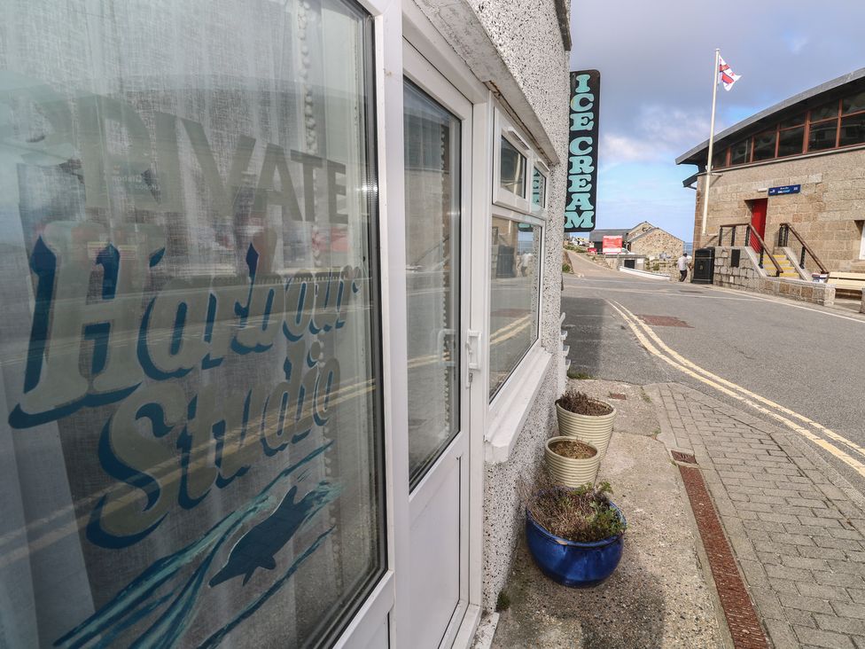 An outdoor view of a sign for Harbour Studio at Sennen Cove