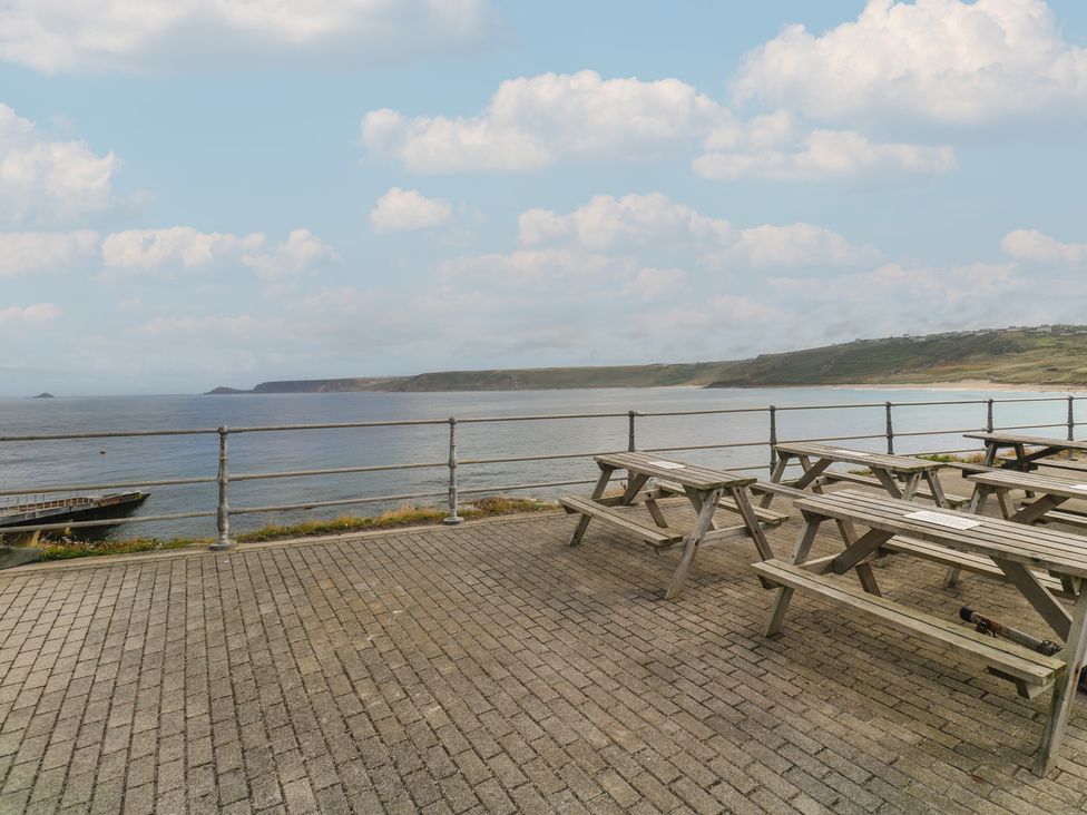 An outdoor seating area near the ocean at Harbour Studio in Sennen Cove