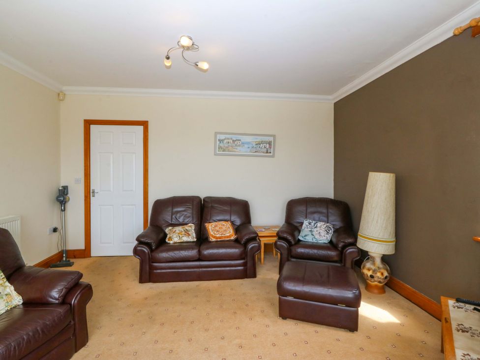 A living room with brown furniture at Cwm Eilir in Criccieth