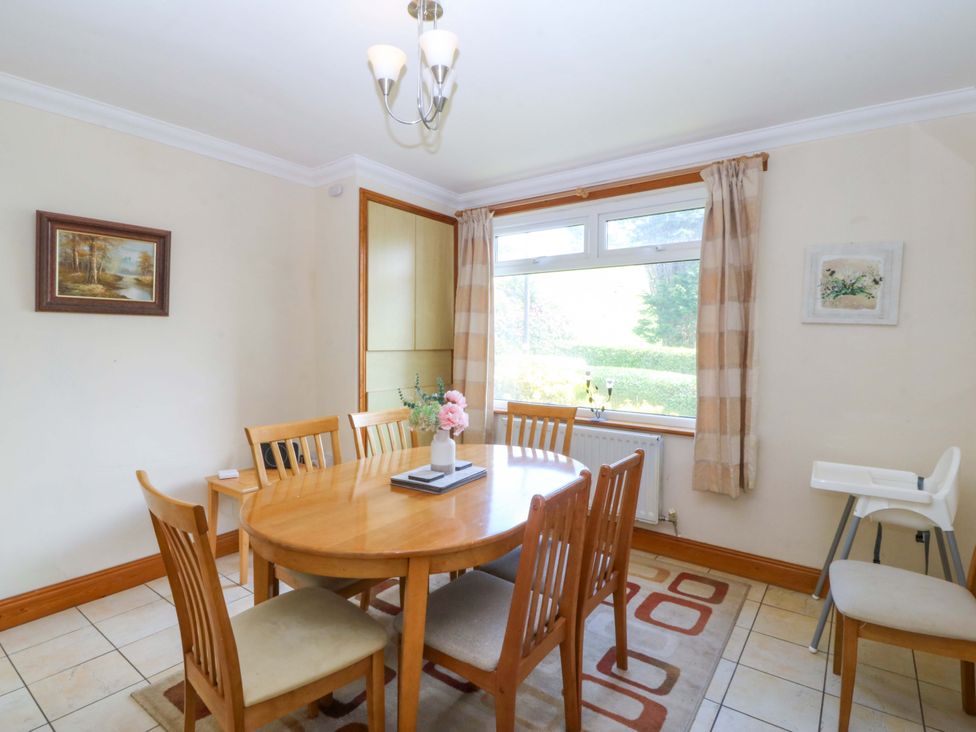A dining room with a table and chairs at Cwm Eilir in Criccieth