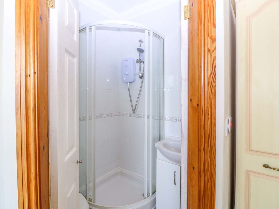 A bathroom with a shower and sink at Cwm Eilir Criccieth