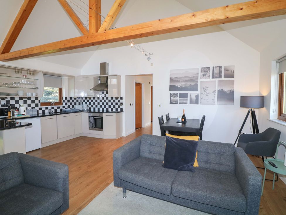 A living room with a sofa and dining area at Lodge 1 South Hykeham