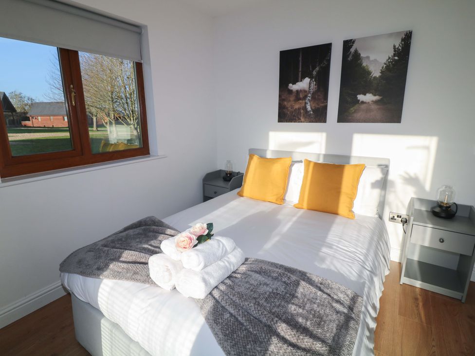 A bedroom with a bed and decorations at Lodge 1 in South Hykeham