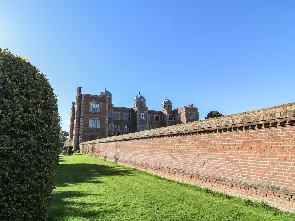 A brick building with a wall and hedge at Lodge 1 South Hykeham