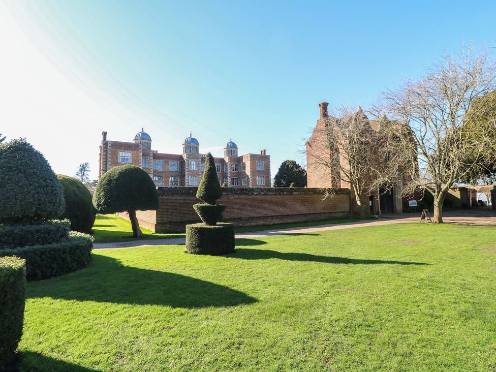 A garden with topiary and a historic building at Lodge 1 South Hykeham