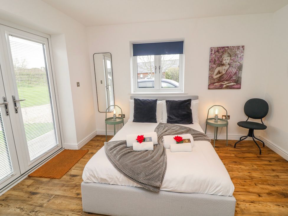 A bedroom with a bed and a chair at Lodge 24 South Hykeham