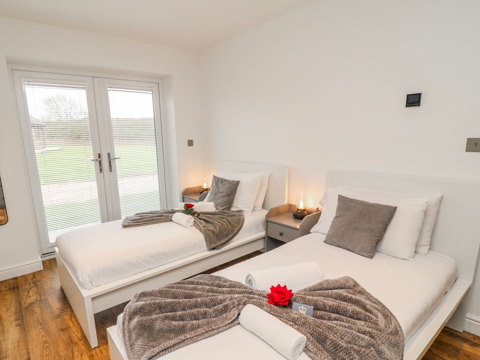 A bedroom with two beds and a rose on the bed at Lodge 24 in South Hykeham