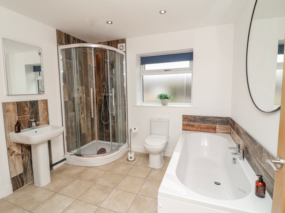 A bathroom with a bathtub, shower, toilet, and sink at Lodge 24 South Hykeham