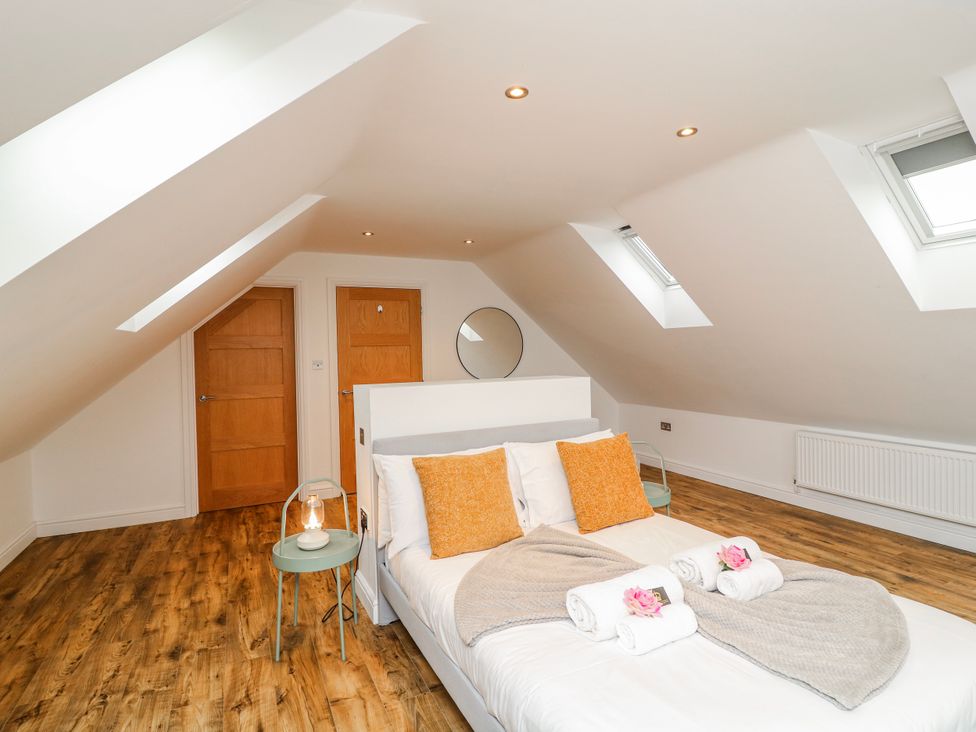 A bedroom with a bed and two doors at Lodge 24 South Hykeham