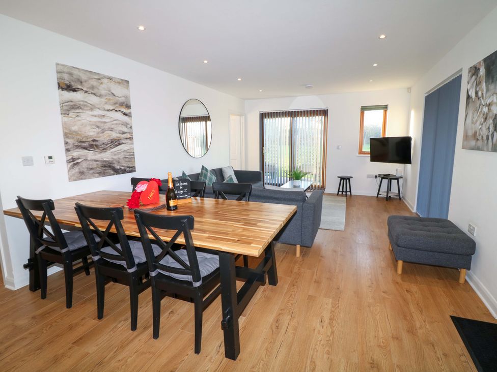 A living room with a dining table and sofa at Lodge 2 in South Hykeham