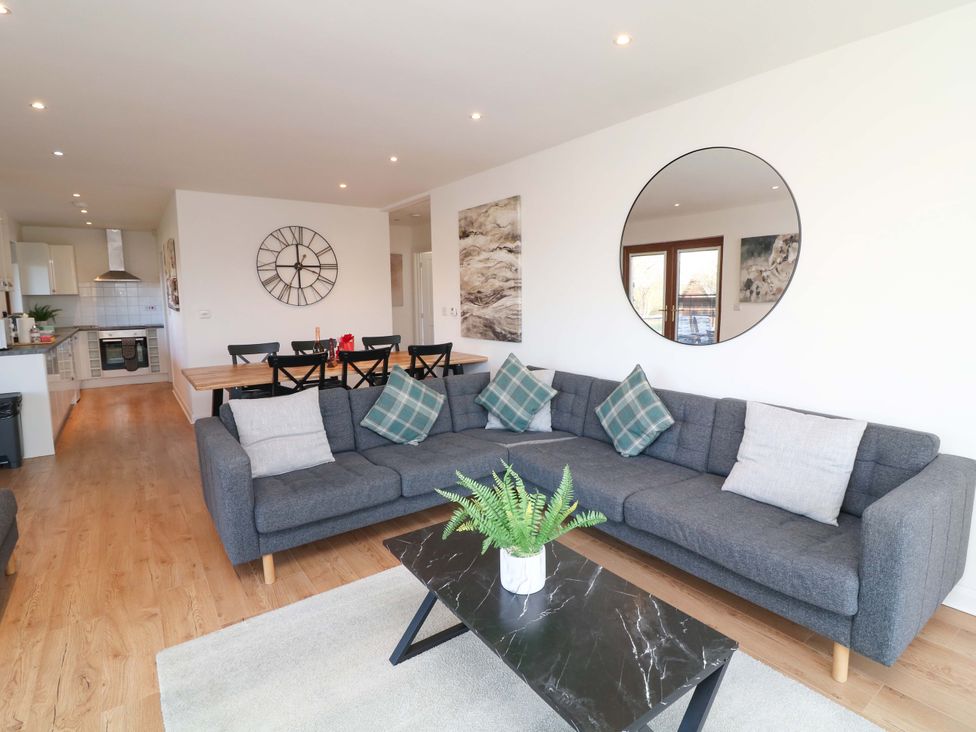 A living room with a sofa and dining area at Lodge 2 South Hykeham