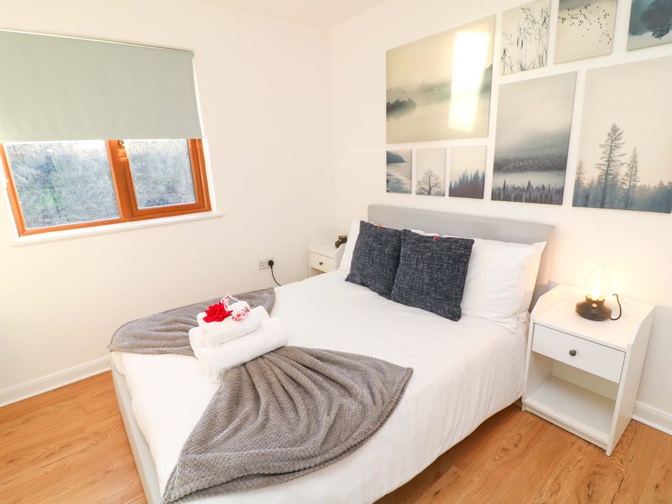 A bedroom with a bed and nightstand at Lodge 2 South Hykeham