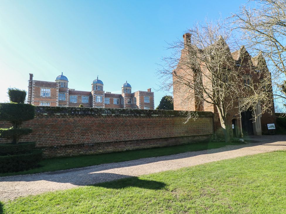 A historic building with a brick wall and trees in front at Lodge 2 South Hykeham