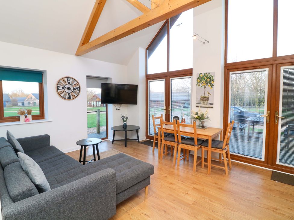 A living room with a sofa, coffee table, and dining area at Lodge 3 Thorpe-On-The-Hill