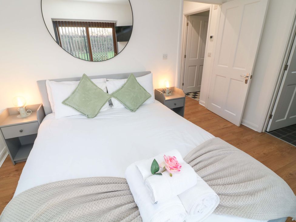 A bedroom with a bed and nightstand at Lodge 3 in Thorpe-On-The-Hill