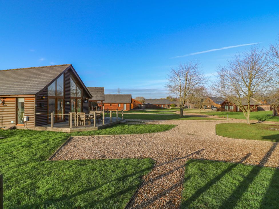 A house with a deck and gravel path at Lodge 3 in Thorpe-On-The-Hill