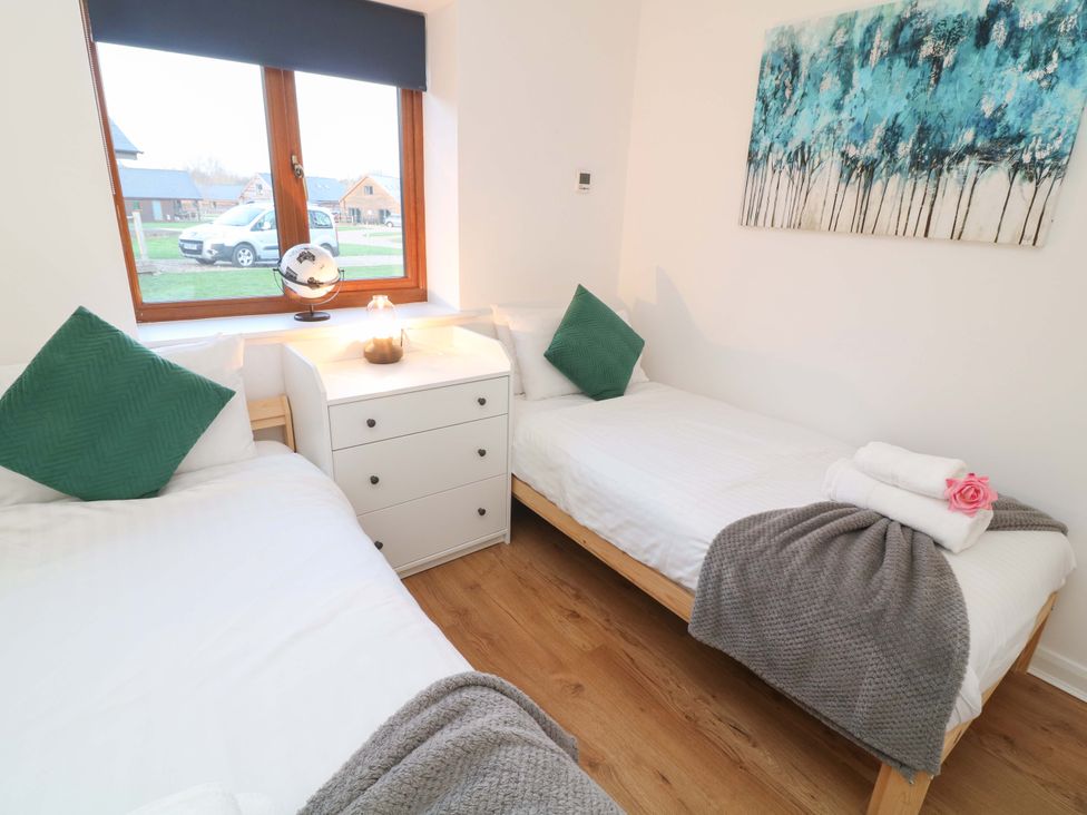 A bedroom with two beds and a dresser at Lodge 3 in Thorpe-On-The-Hill