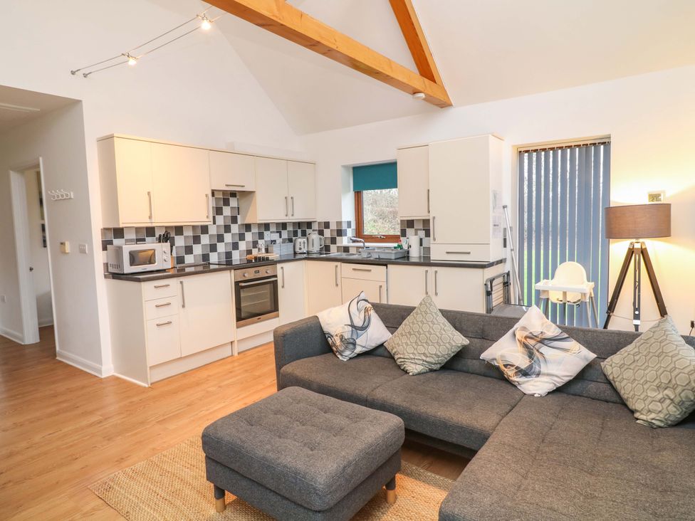 A living room and kitchen area with a sofa and kitchen units at Lodge 4 South Hykeham