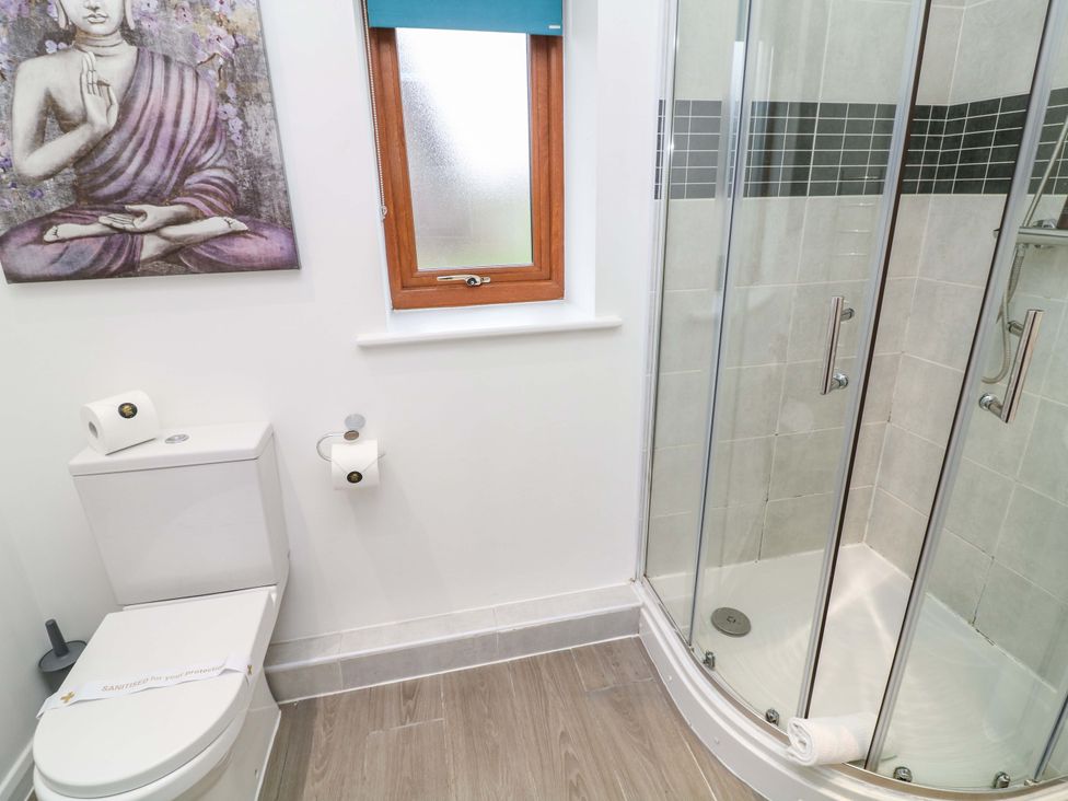 A bathroom with a toilet and shower featuring wall art at Lodge 4 in South Hykeham