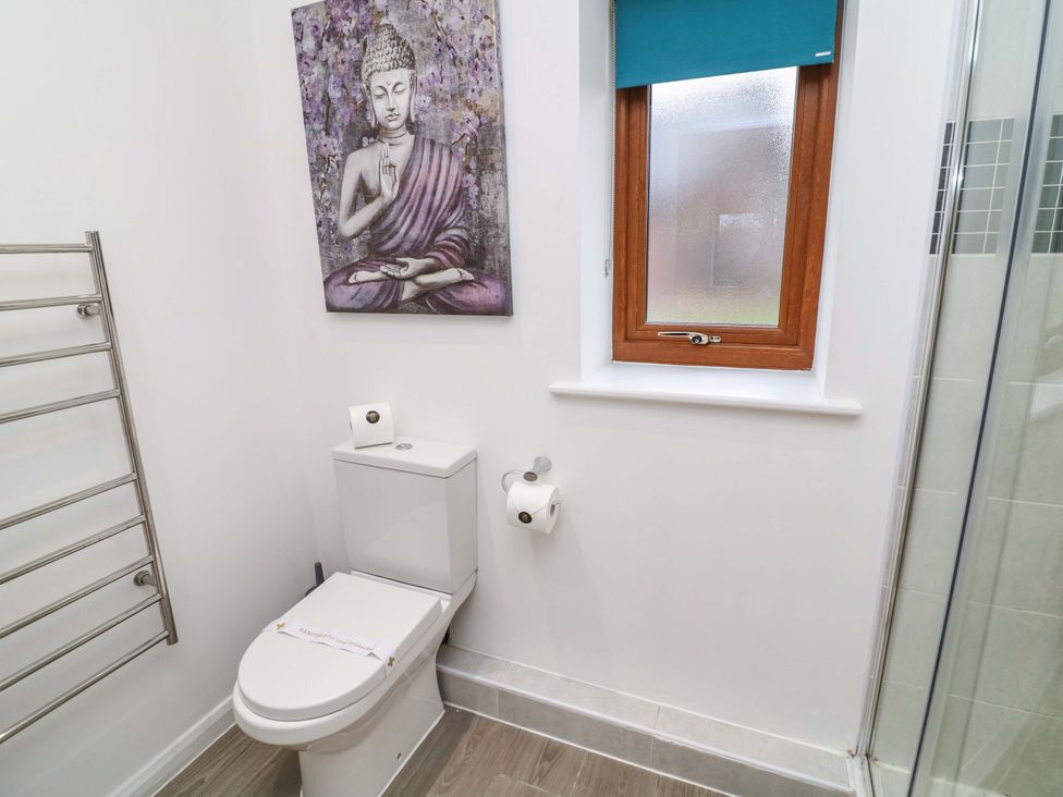 A bathroom with a toilet and a window at Lodge 4 South Hykeham