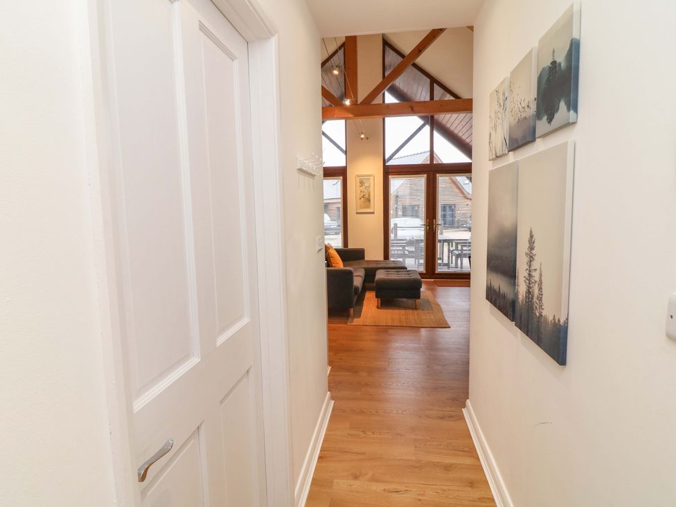 A hallway leading to a living area with large windows at Lodge 7 in South Hykeham