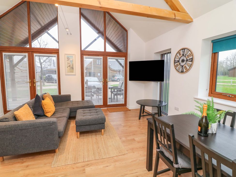 A living room with a sofa and dining table at Lodge 7 in South Hykeham