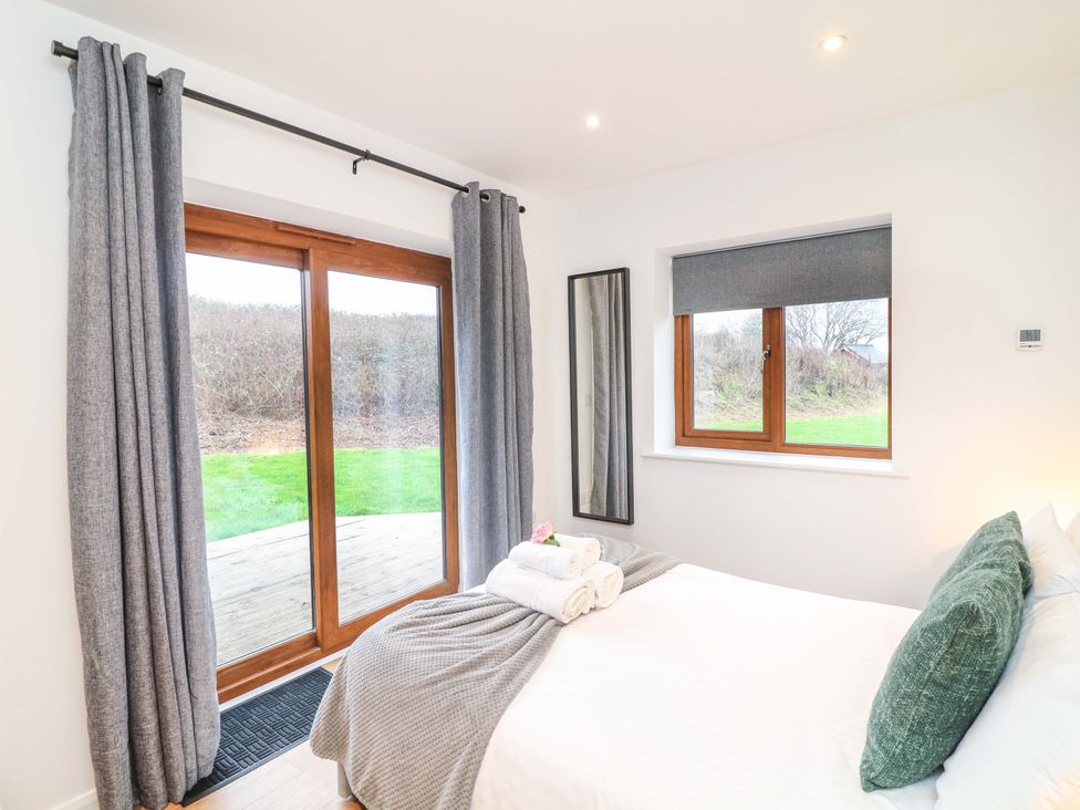 A bedroom with a bed and windows at Lodge 7 South Hykeham