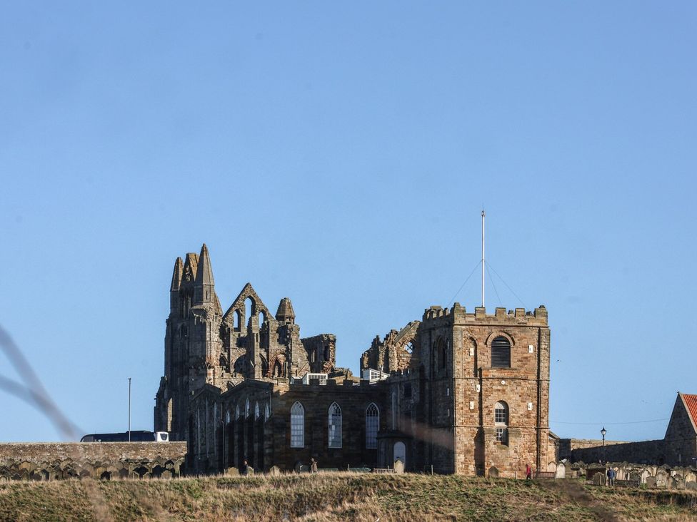 Ruins of a stone building with windows and a flagpole at 5 Hall Yard Whitby