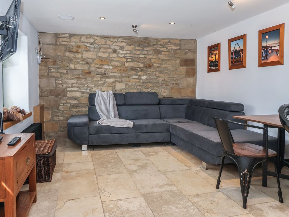 A living room with a sofa and a table at 5 Hall Yard in Whitby