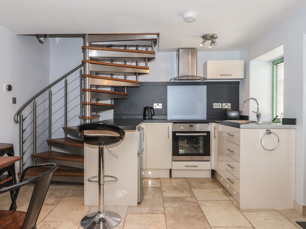 A kitchen with a spiral staircase and modern appliances at 5 Hall Yard in Whitby