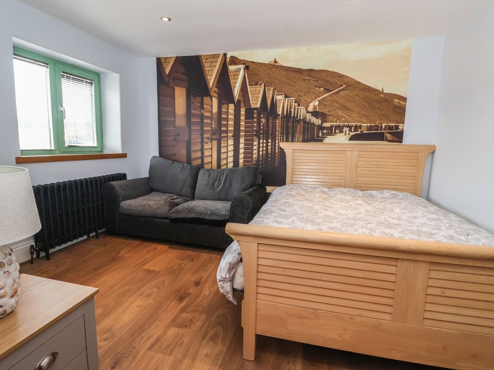A bedroom with a bed and sofa at 5 Hall Yard in Whitby