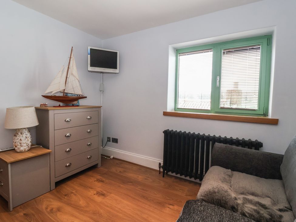 A bedroom with a sofa and chest of drawers at 5 Hall Yard in Whitby
