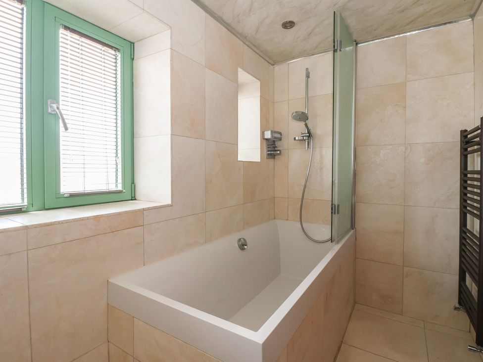A bathroom with a bath tub and a shower at 5 Hall Yard in Whitby