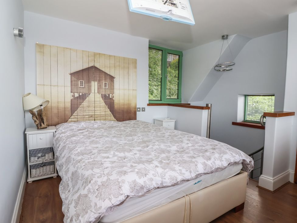 A bedroom with a bed, bedside lamp, and wall art at 5 Hall Yard in Whitby