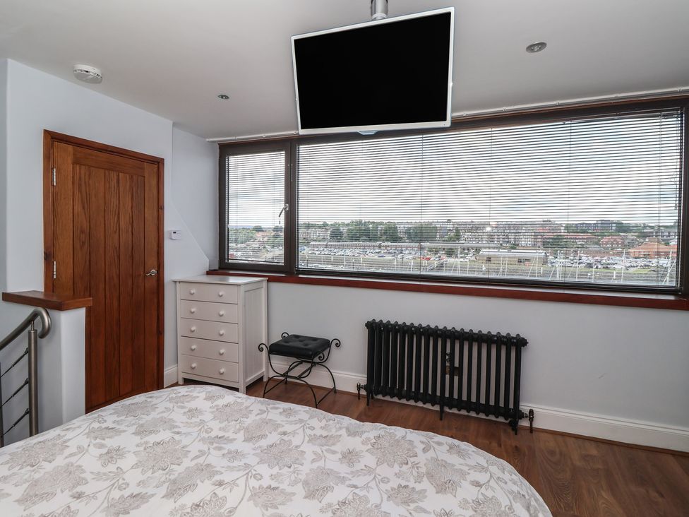 A bedroom with a dresser and television at 5 Hall Yard in Whitby