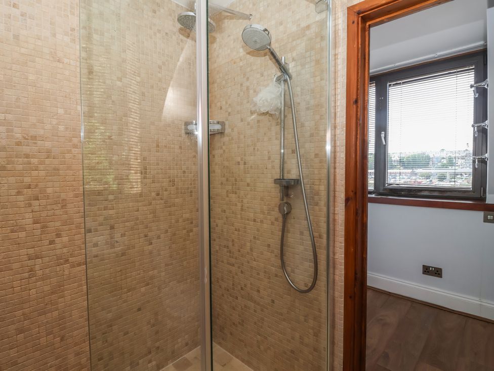 A shower with mosaic tiles and glass door at 5 Hall Yard in Whitby