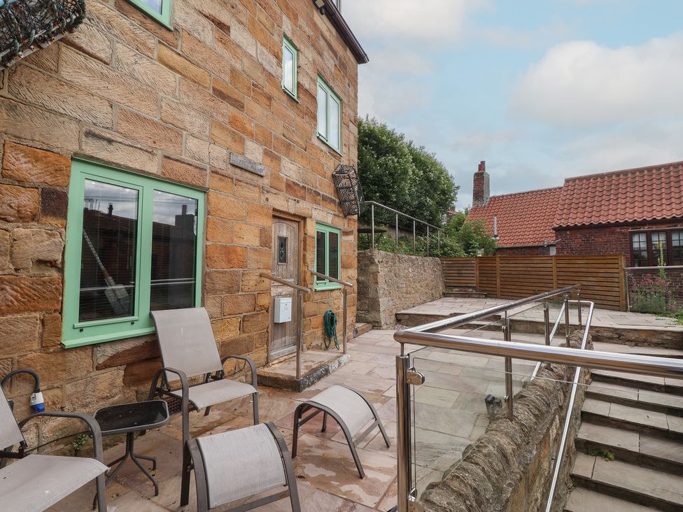An outdoor area with a building, chairs and steps at 5 Hall Yard Whitby